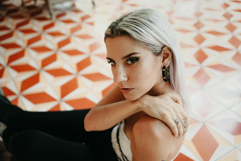 a woman with blonde hair sitting on the floor