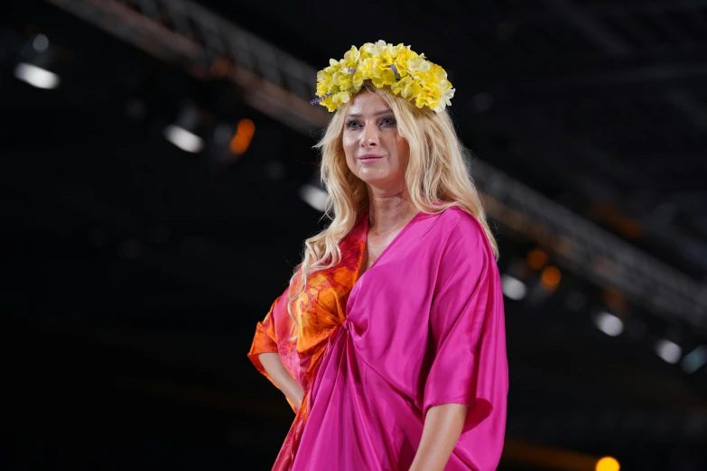 the woman in pink dress wears a floral wreath