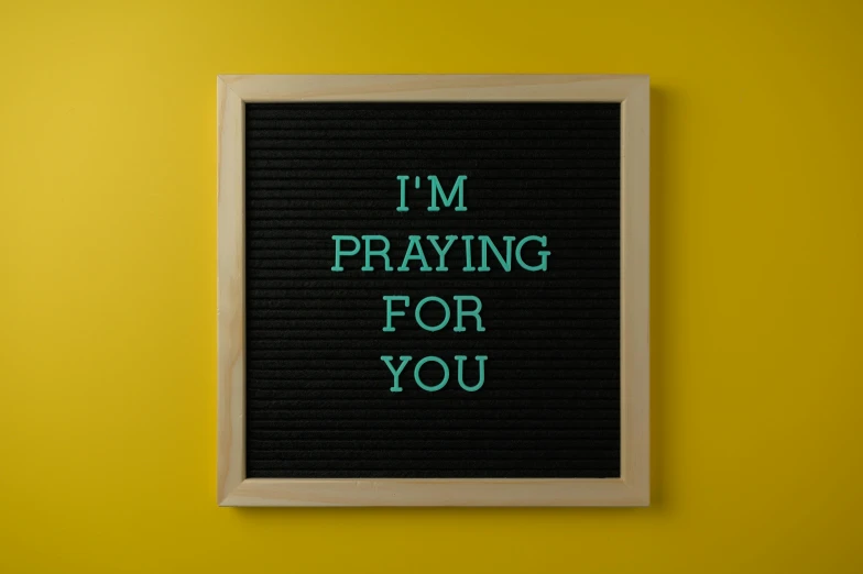 a letter board with a picture frame underneath it reading i'm praying for you