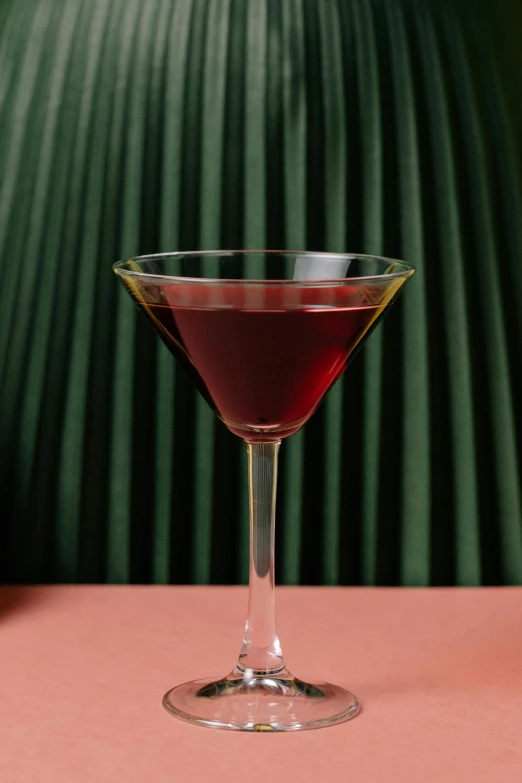 a small glass filled with red liquid on top of a table