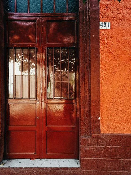 a red building with two brown doors on either side