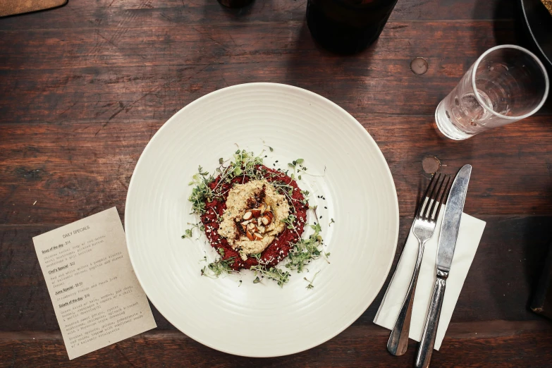 a white plate with sauce on it with silverware