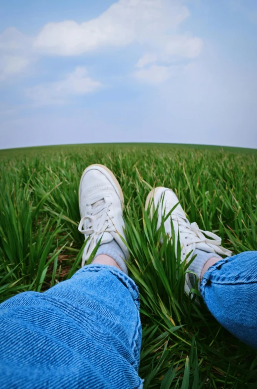 there is a white tennis shoe that is sitting in the grass