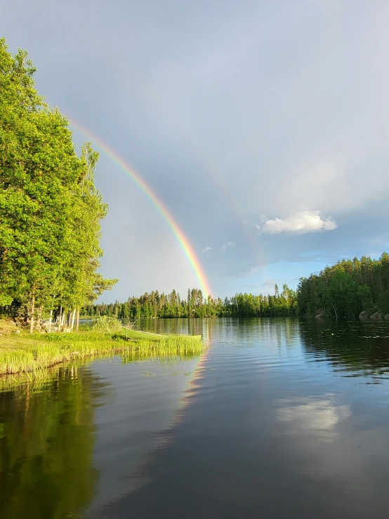 a rainbow appears over the water in the evening