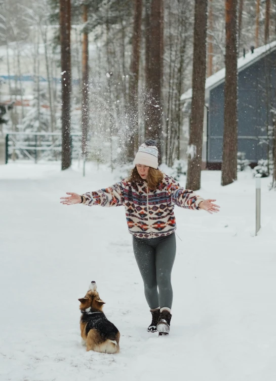 a woman walking two dogs in the snow