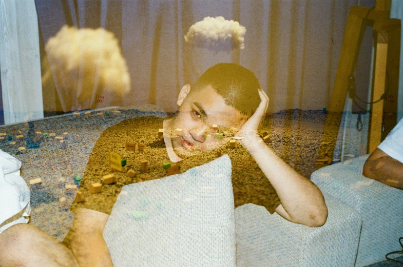 a young man sitting on top of a bed