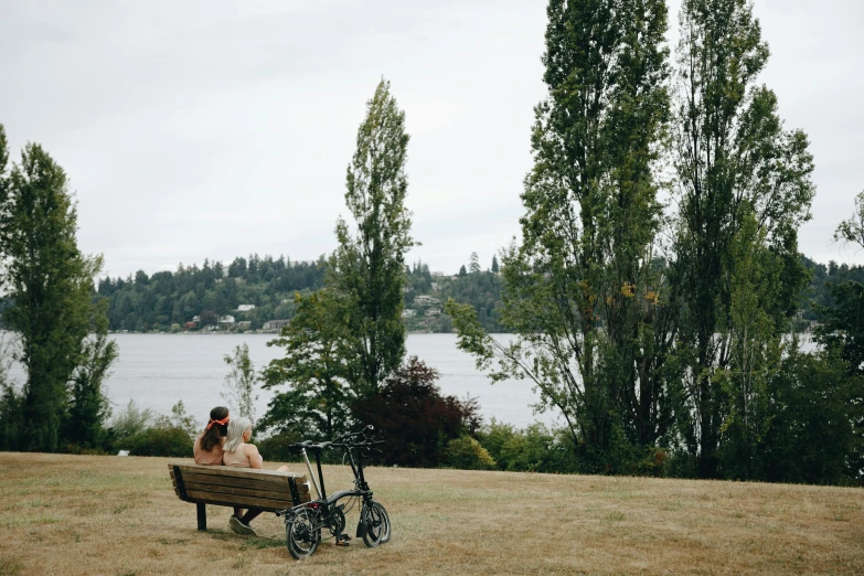 a couple sitting on a bench looking out over the water