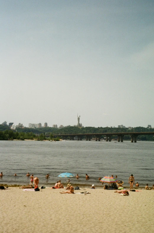 people are on the sand near the water