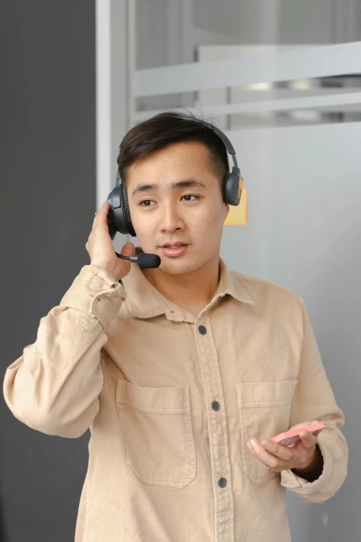 a man talking on a cell phone with his hands and wearing headphones