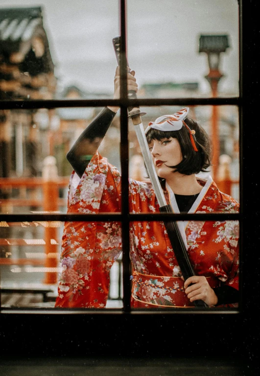 woman in red kimono holding an oriental sword
