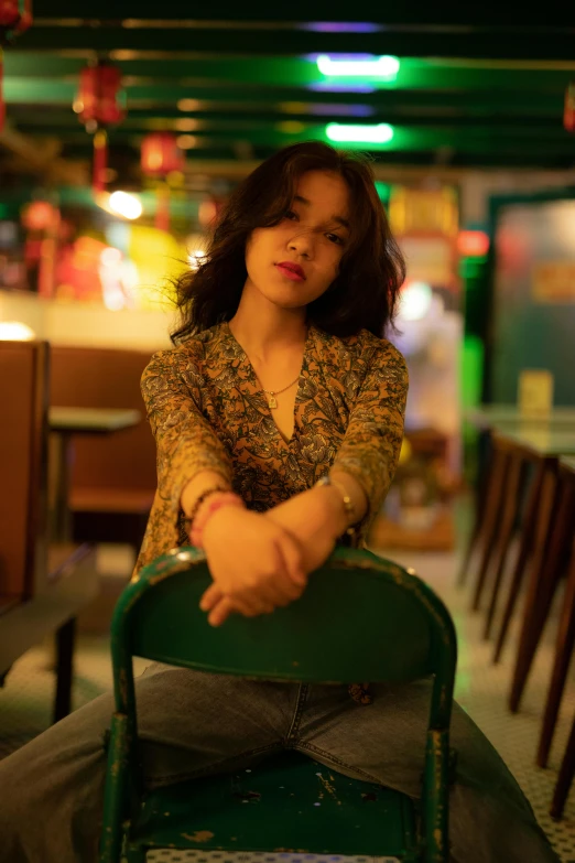 an asian woman is sitting on a chair in a restaurant