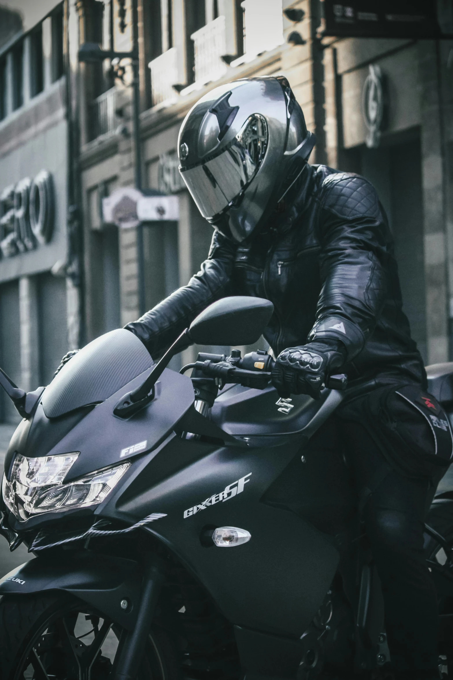 man riding a motorcycle with black leather jacket and helmet