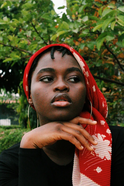 a woman in a scarf looks out from the background