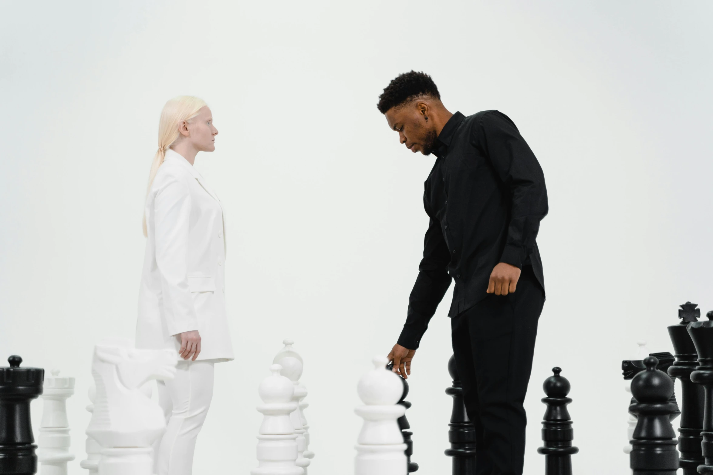 there are two men standing in front of chess pieces