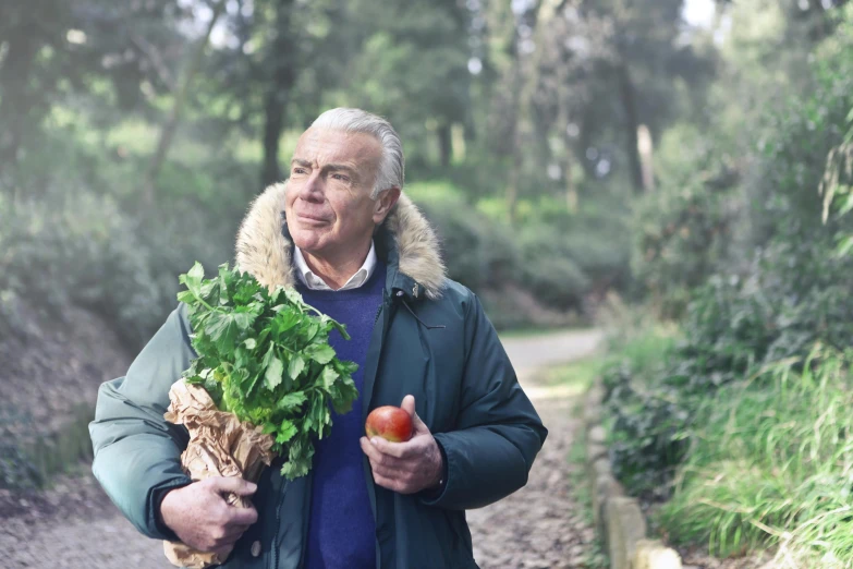 a man holding a bunch of vegetables in his hand