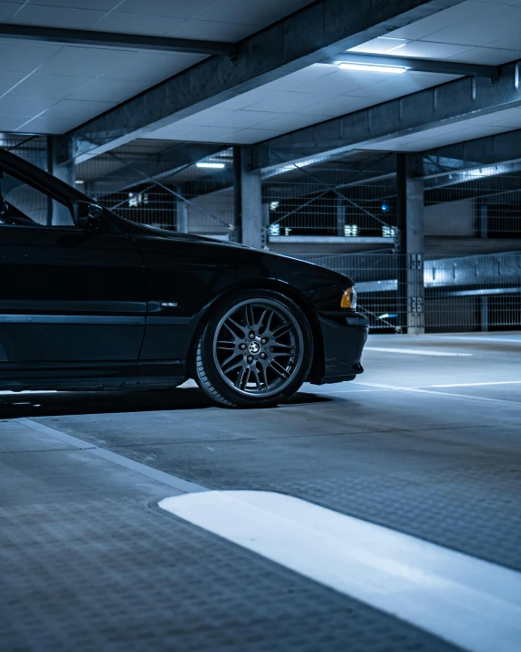 a black car is parked inside a parking garage