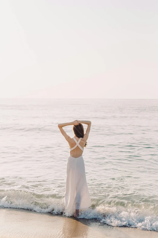 a woman standing at the edge of the ocean