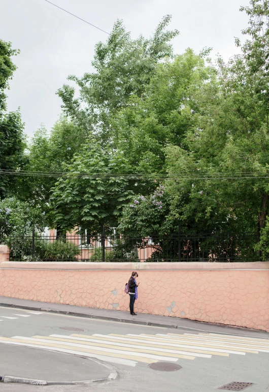 a man with an umbrella stands on the corner