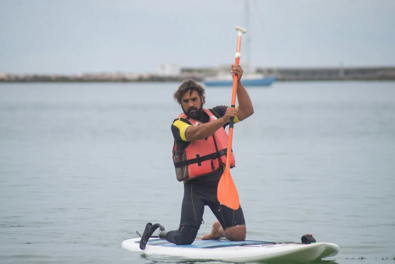 a man paddles a surf board in the water