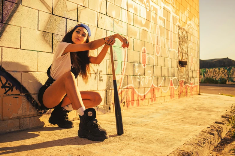 a beautiful woman sitting on a ledge leaning up against a wall