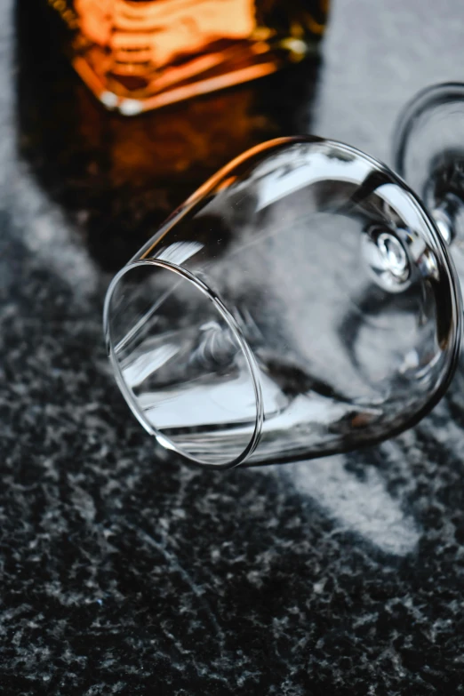 a glass on a counter by an empty glass