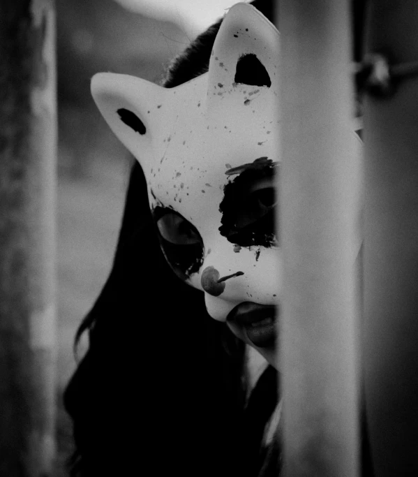 a creepy woman wearing a cat mask over her head