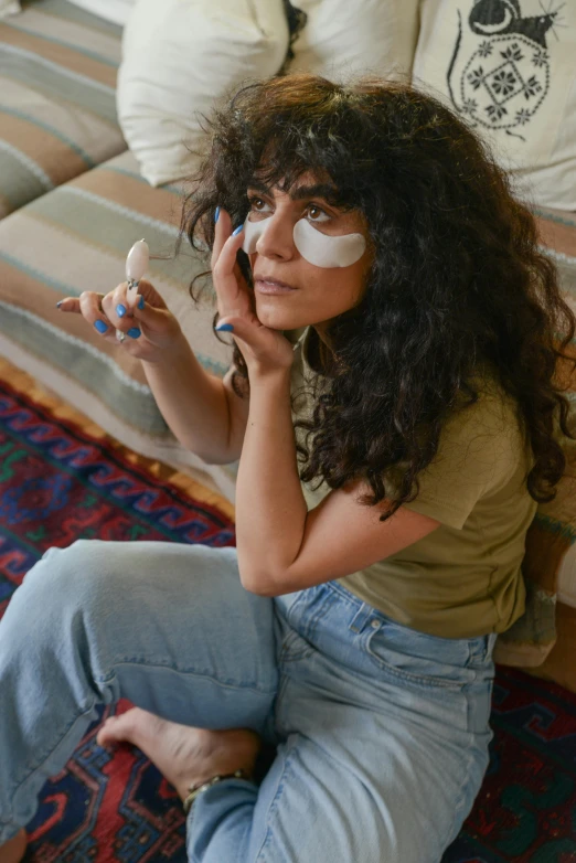 a woman with eye patches on sitting and looking at the camera