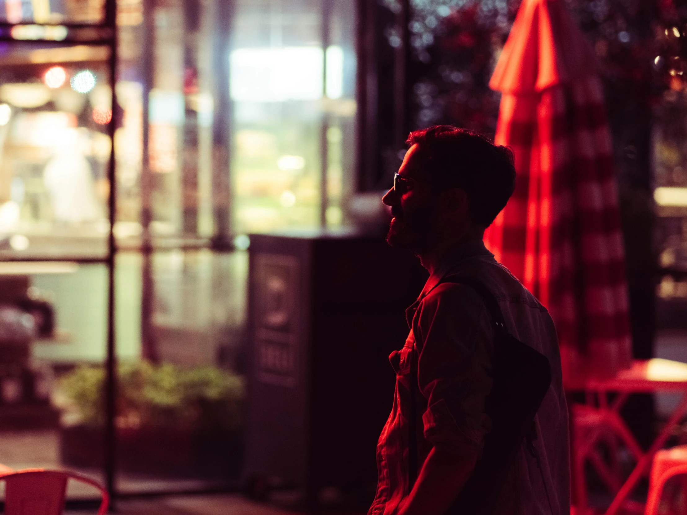 the man stands outside at night in front of the light