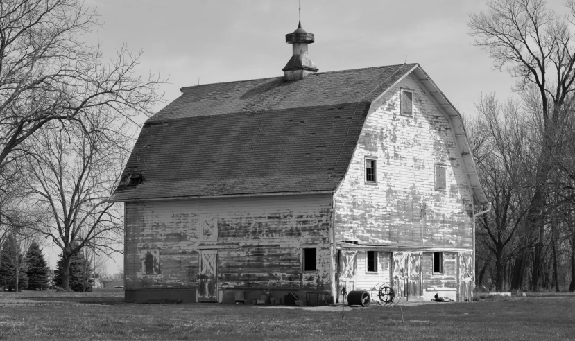 a black and white pograph of a old barn