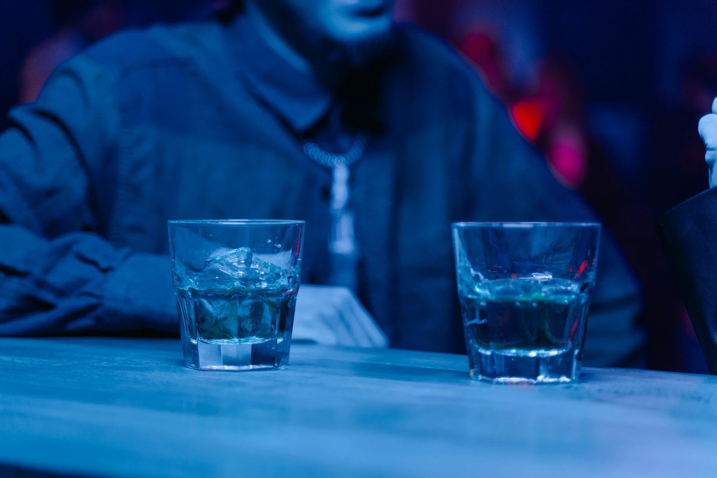 two glasses of water sitting on a table