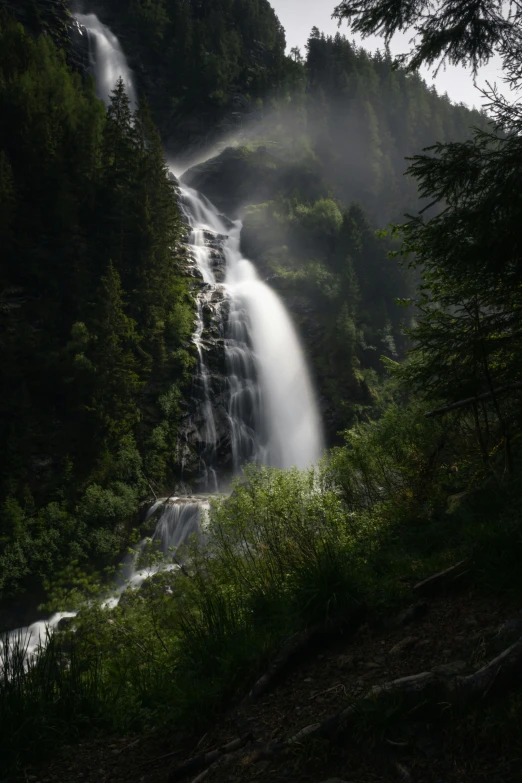 the falls are very tall and foggy in the valley