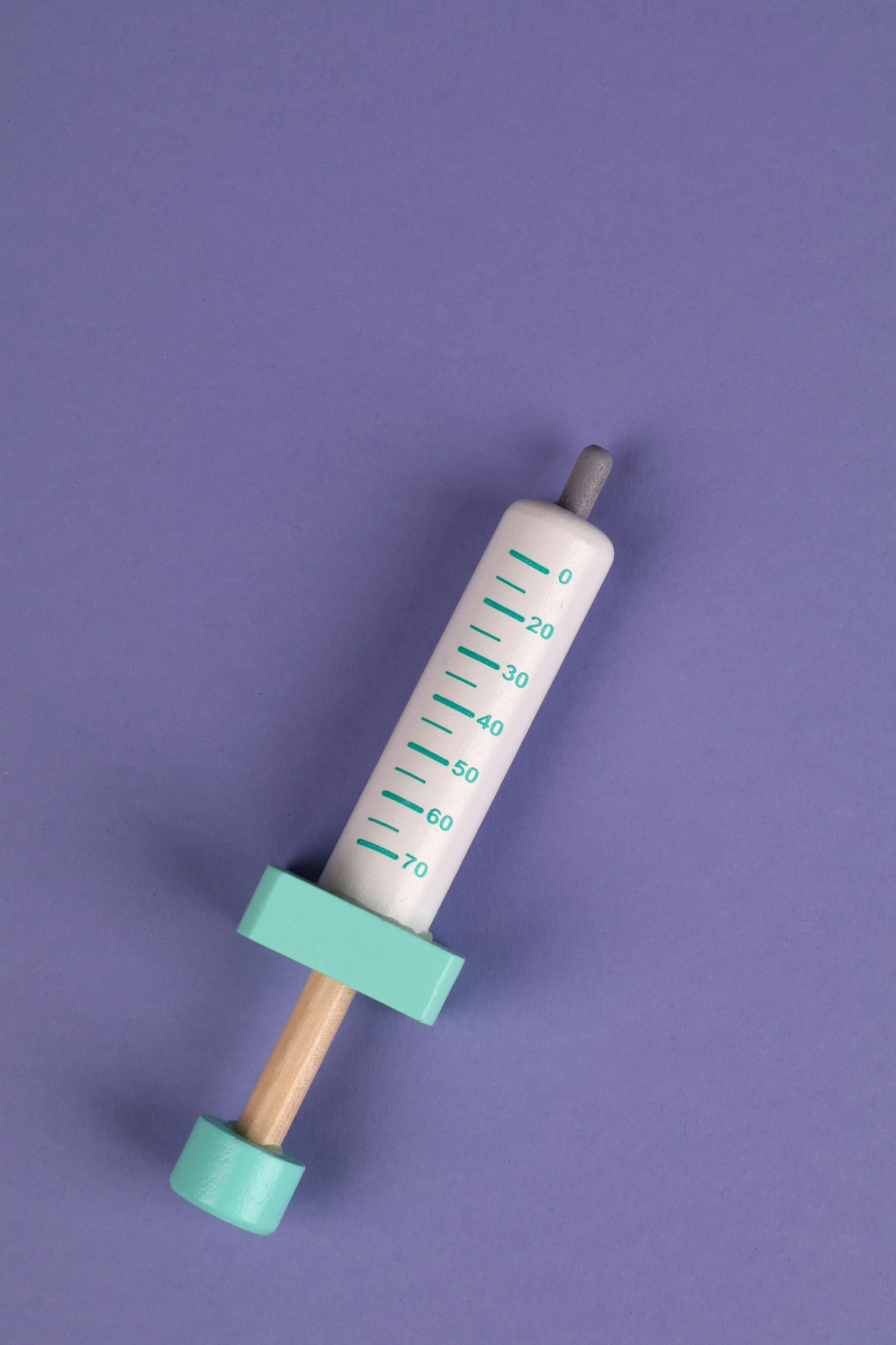 a tube with an empty medicine dropper on a light blue background