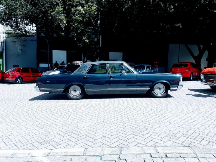 a blue car is parked in the parking lot next to other vehicles