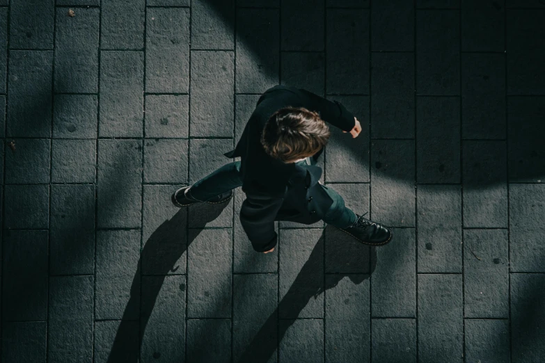 a man standing on a sidewalk with one leg on his hips