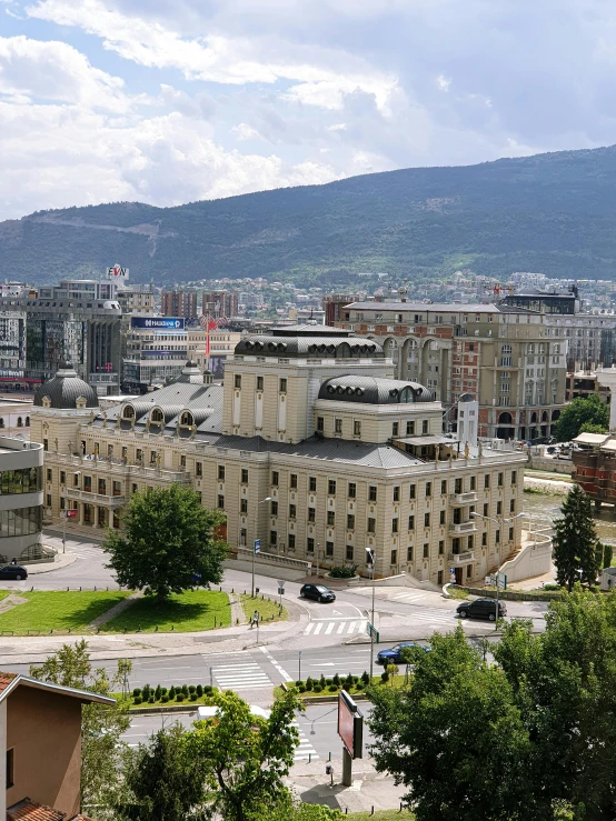 this is a city with buildings and many hills in the background