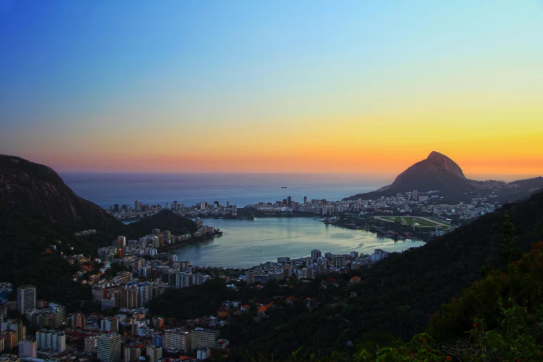 the sun sets over the city skyline in rio
