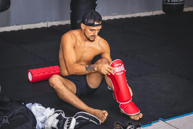 a man kneels on the ground with boxing gloves and a punching glove