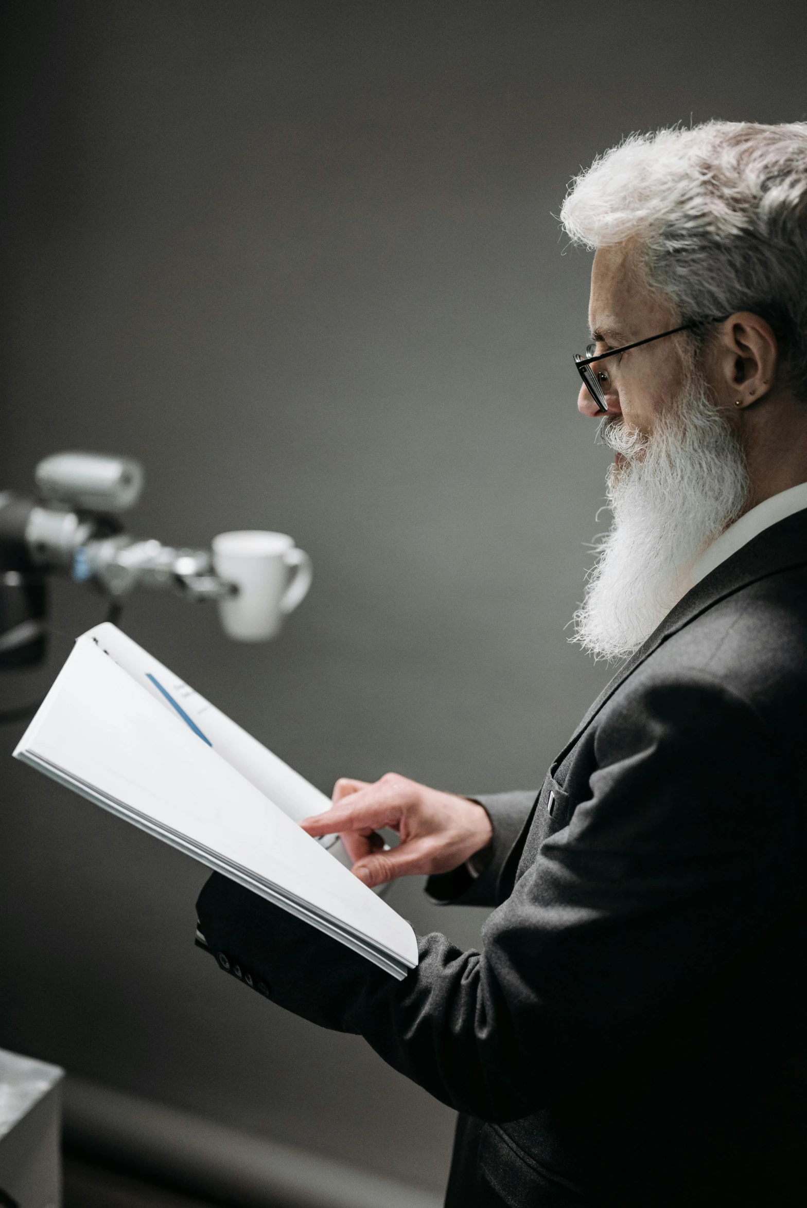 a man in glasses holding an open book