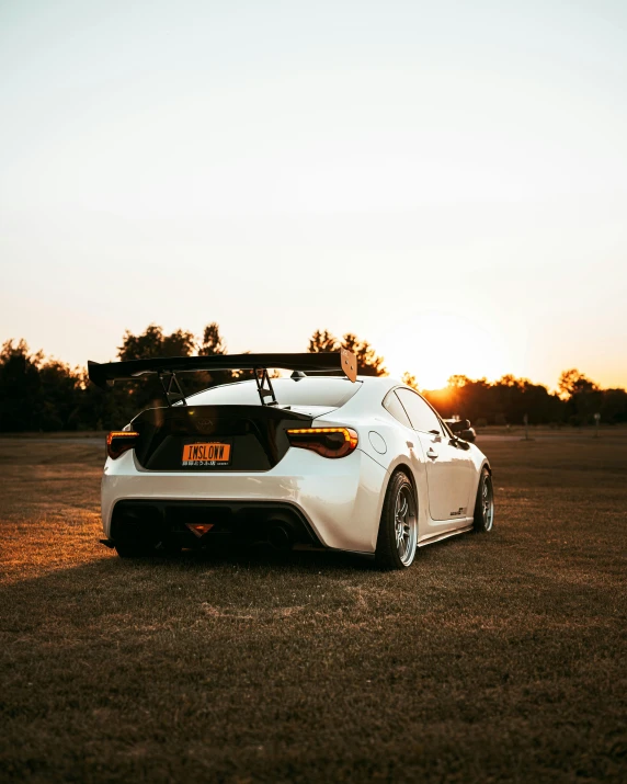 a white car is parked in an open field