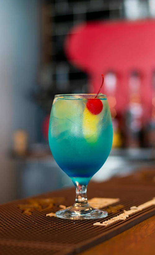 a colorful drink with a cherry on top