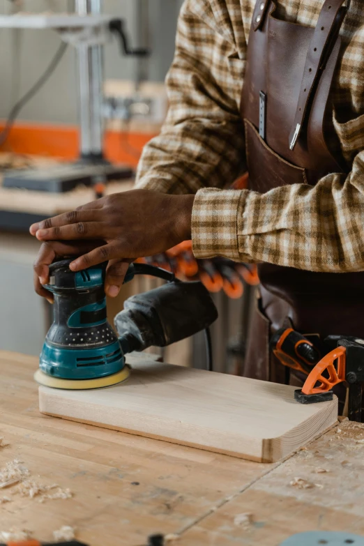 a man working with an electric sander