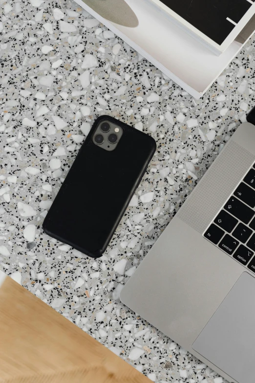 a laptop, a phone and a keyboard on a surface