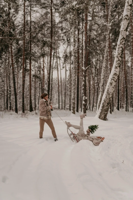 woman using a sled to pull a man in snow