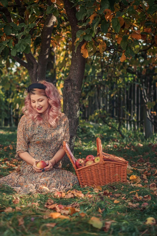 a woman in an ornate dress sits under a tree