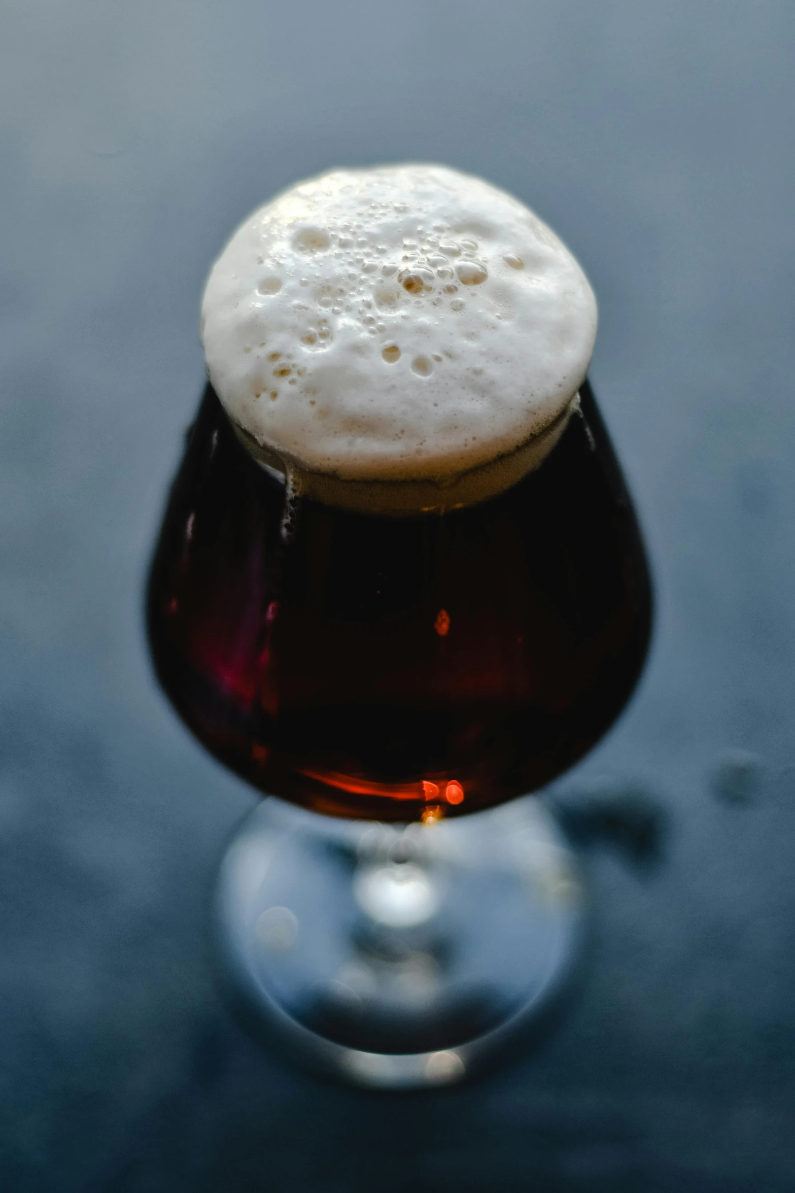 a glass filled with some beer on top of a table