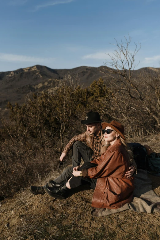 the couple is sitting on the edge of a cliff