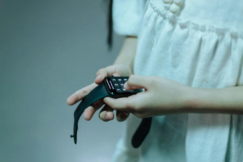 a girl holding onto a cell phone with both hands