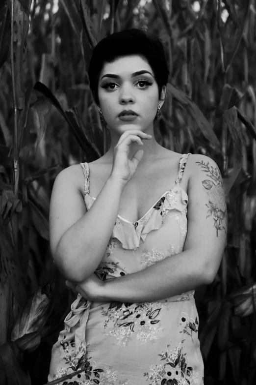 an asian woman standing next to the cornfield