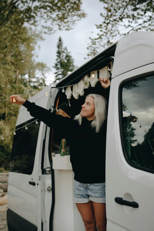 there is a woman holding food inside of the back of a truck