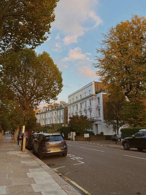 cars are parked on the side of the street as the sun is set